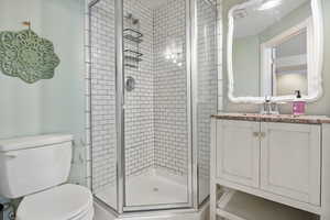 Full bathroom featuring vanity and a shower stall