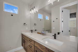 Bathroom featuring double vanity and baseboards