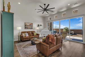 Living area with ceiling fan, wood finished floors, and recessed lighting