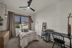 Bedroom with carpet floors, ceiling fan, a desk, and vaulted ceiling
