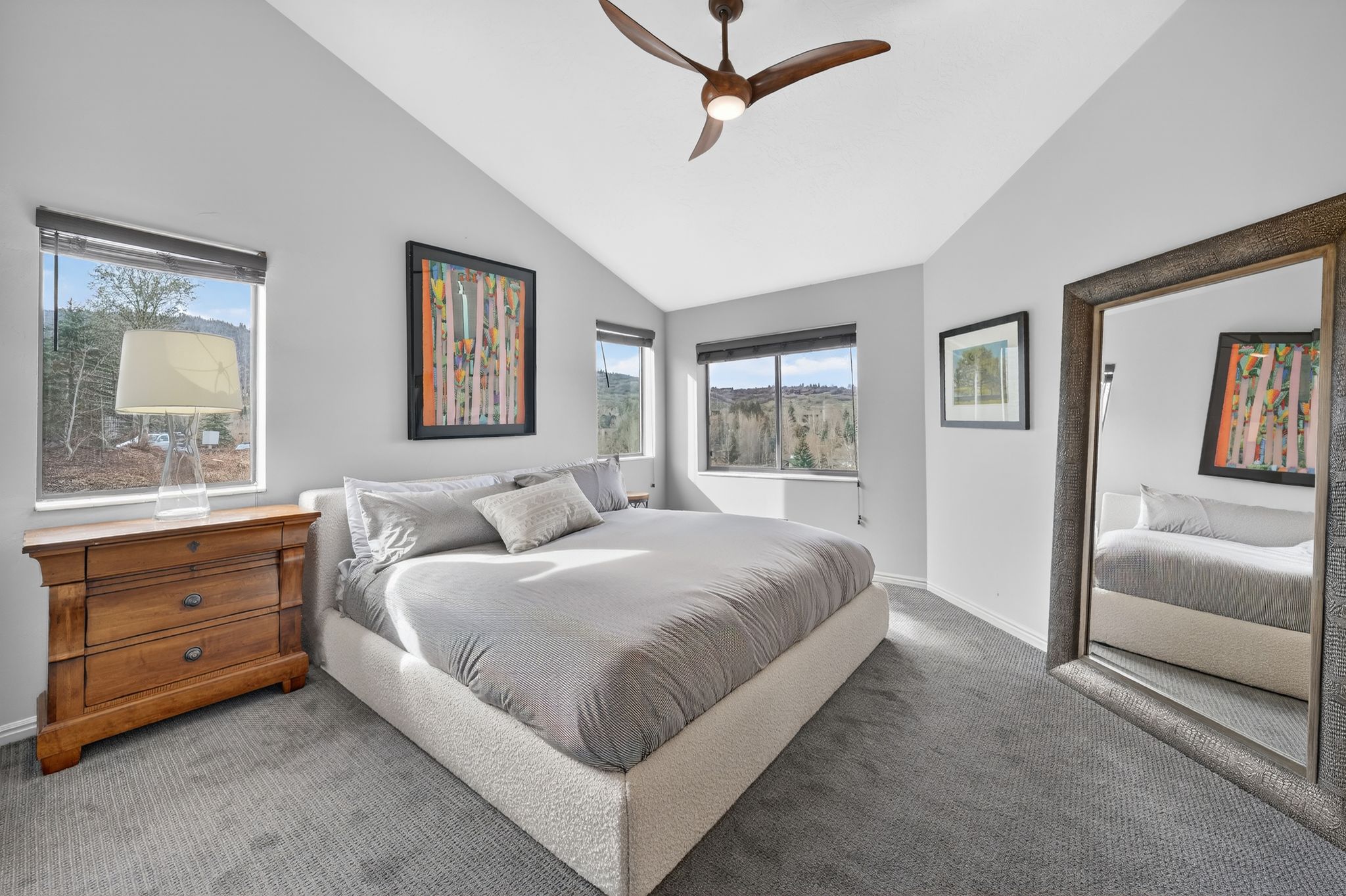Carpeted bedroom with vaulted ceiling and a ceiling fan