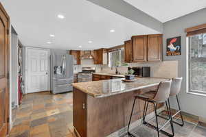 Kitchen with stone tile floors, tasteful backsplash, stainless steel appliances, wood finish cabinets, and recessed lighting
