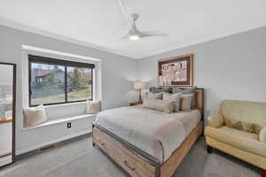 Bedroom featuring carpet, a ceiling fan, and ornamental molding