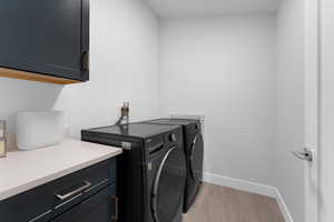 Laundry room with separate washer and dryer and cabinet space
