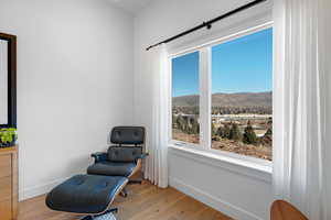 Sitting room with a mountain view and light wood-style flooring