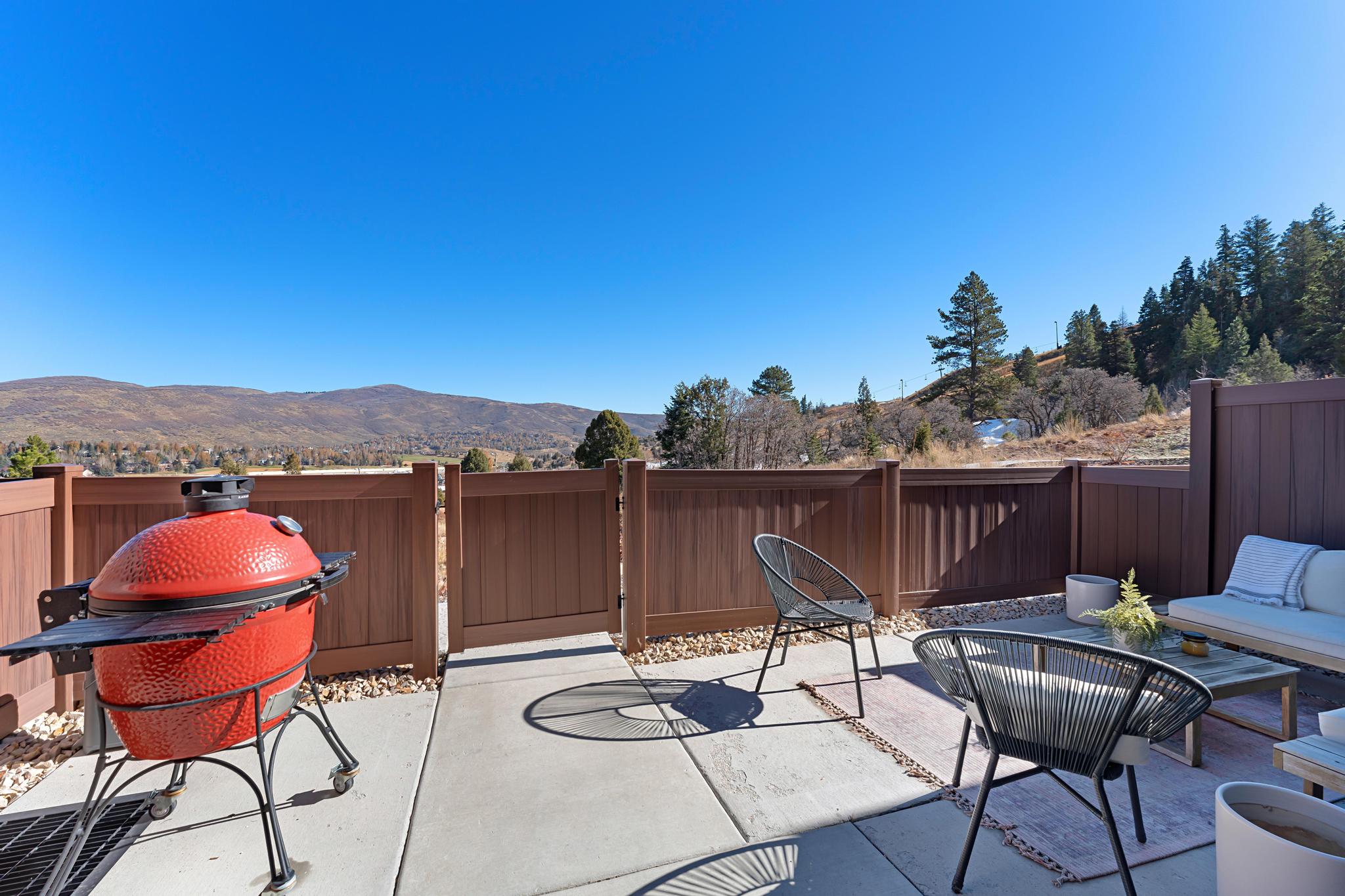 Fenced backyard with a patio area, outdoor seating, a mountain view, and a grill