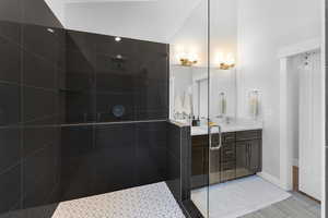 Full bathroom with double vanity and a walk in shower