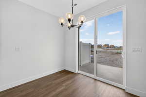 Unfurnished dining area with a chandelier and dark wood-type flooring