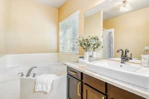 Primary Bathroom featuring vanity and bath