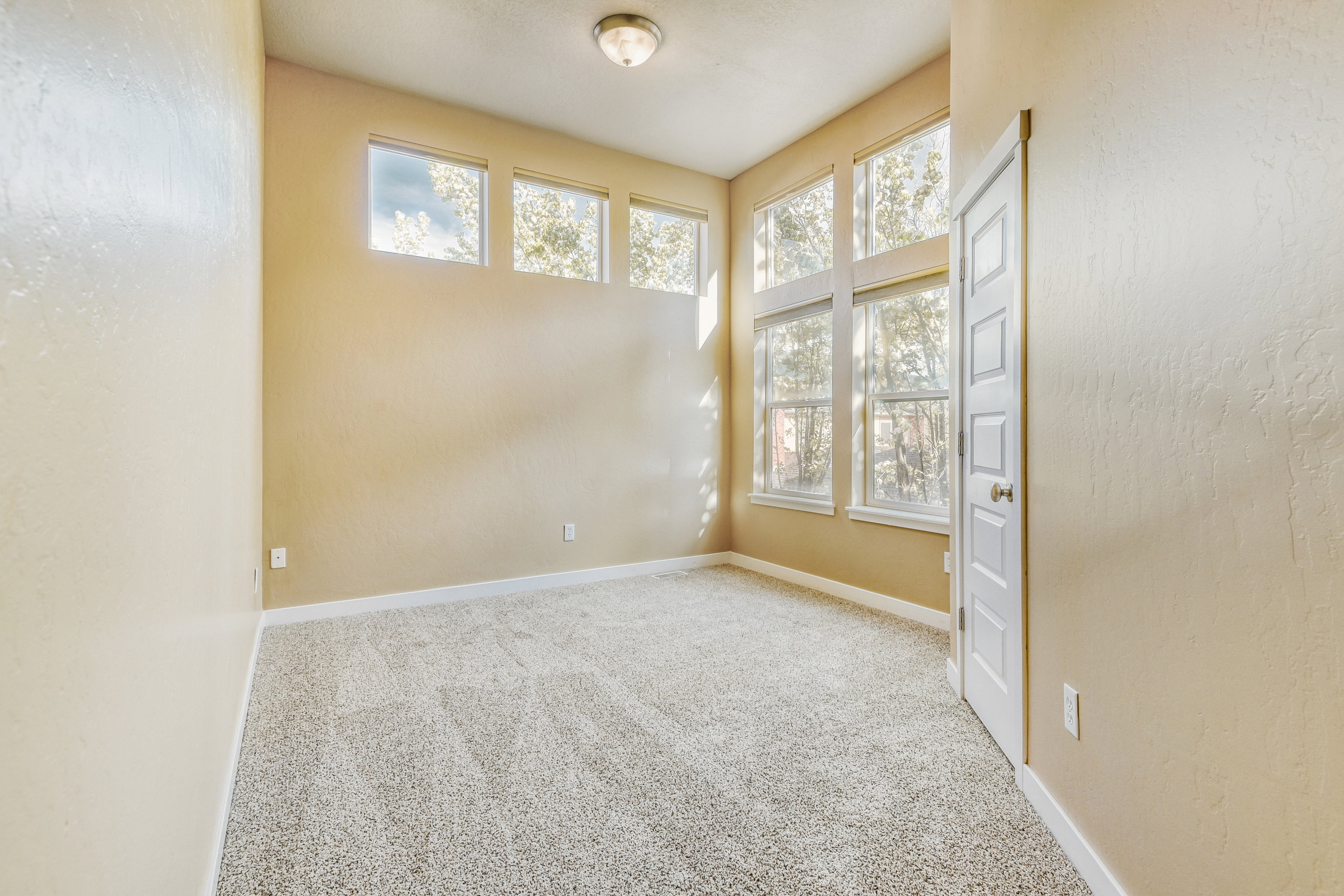 Third bedroom with high ceilings and extensive windows