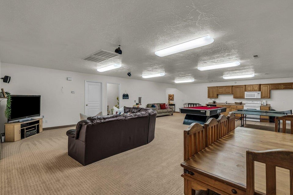 Living area featuring light carpet, a textured ceiling, and pool table