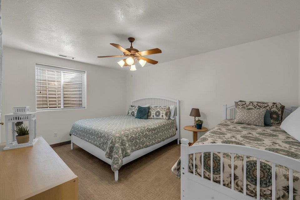 Carpeted bedroom featuring a textured ceiling and a ceiling fan