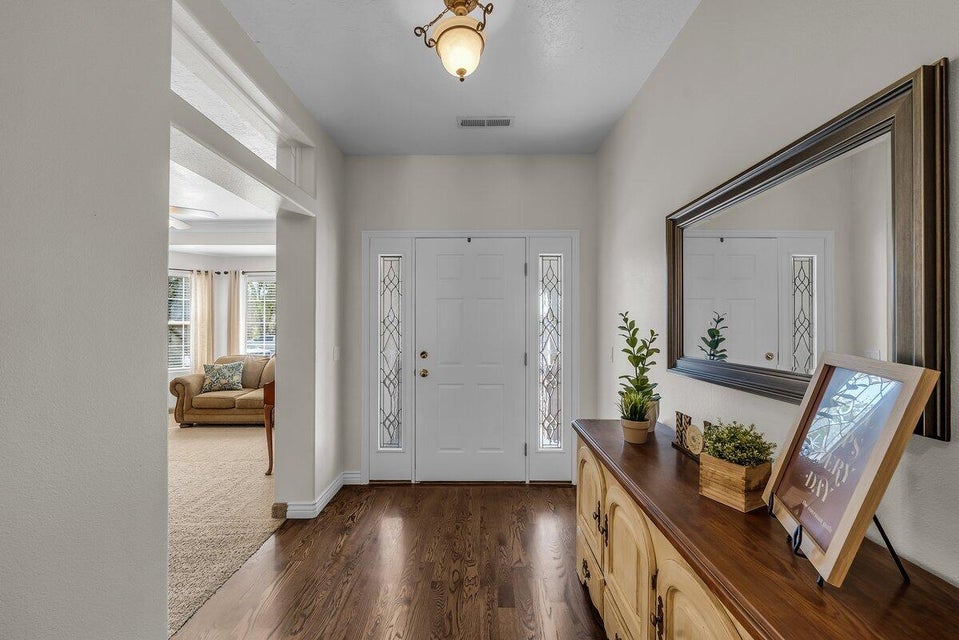 Entrance foyer with dark wood-style floors and baseboards