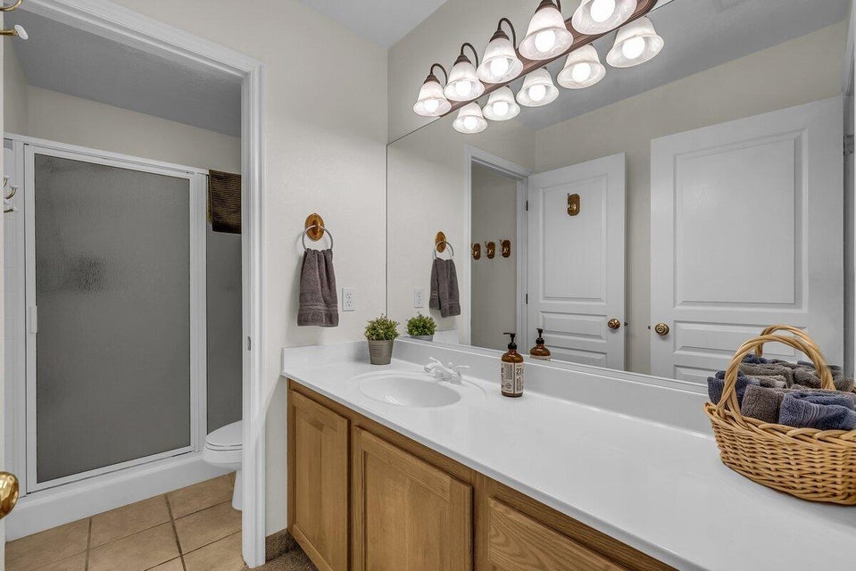 Full bathroom featuring vanity, light tile patterned flooring, and a stall shower
