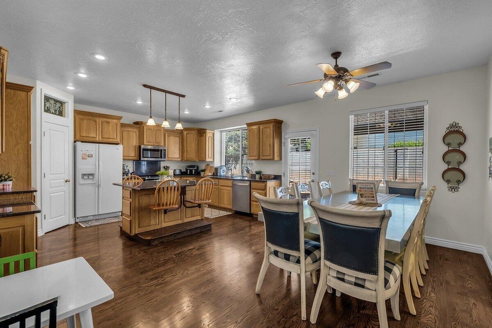 Dining room with dark wood-type flooring, recessed lighting, a textured ceiling, and ceiling fan