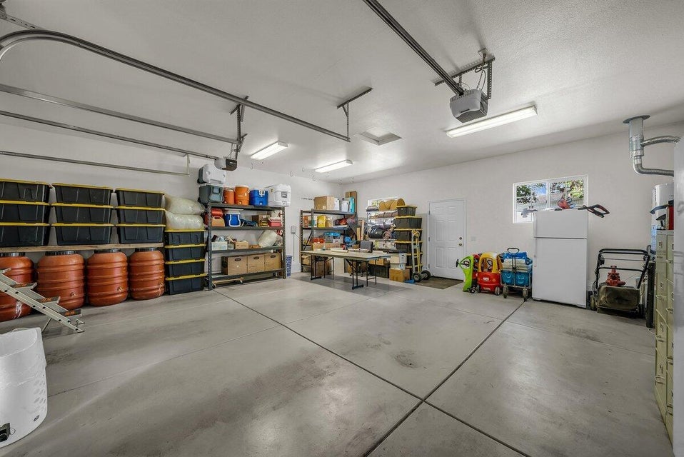 Garage with freestanding refrigerator and a garage door opener