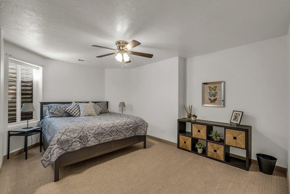 Bedroom with carpet floors, a textured ceiling, and ceiling fan
