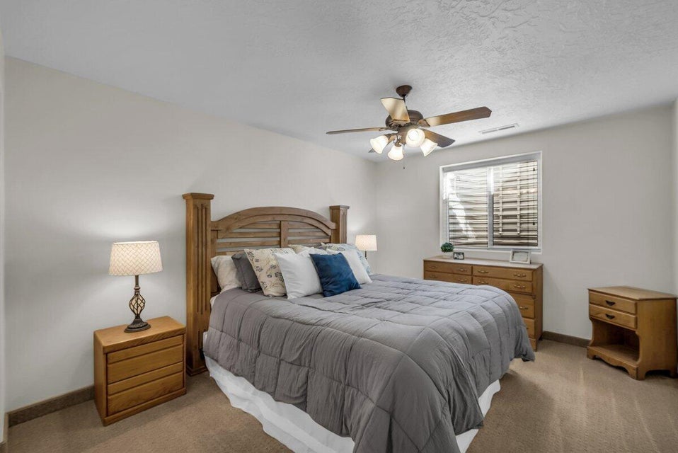 Bedroom featuring carpet, ceiling fan, and a textured ceiling