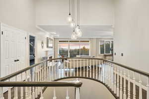 Hallway with crown molding and a high ceiling