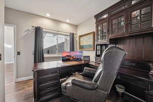 Office area with dark wood-type flooring and recessed lighting