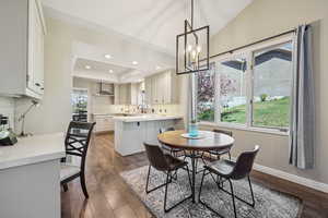 Dining area featuring dark wood finished floors, suspended lighting, and a tray ceiling