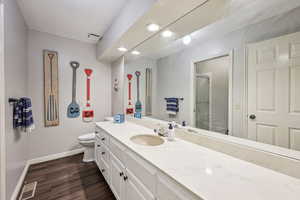 Bathroom with vanity, a stall shower, dark wood-type flooring, and recessed lighting
