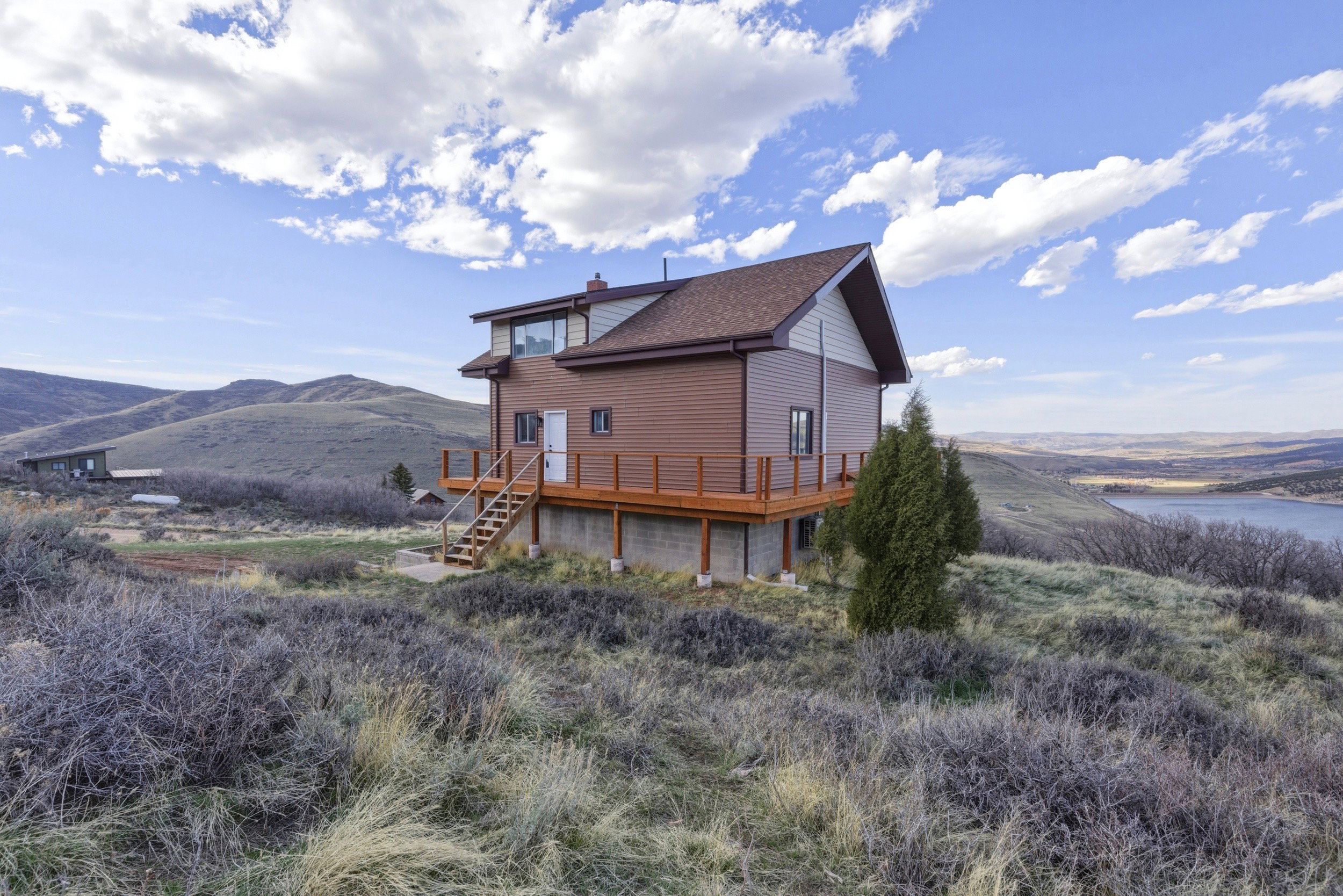 Rear view of property with a deck with water view and a chimney