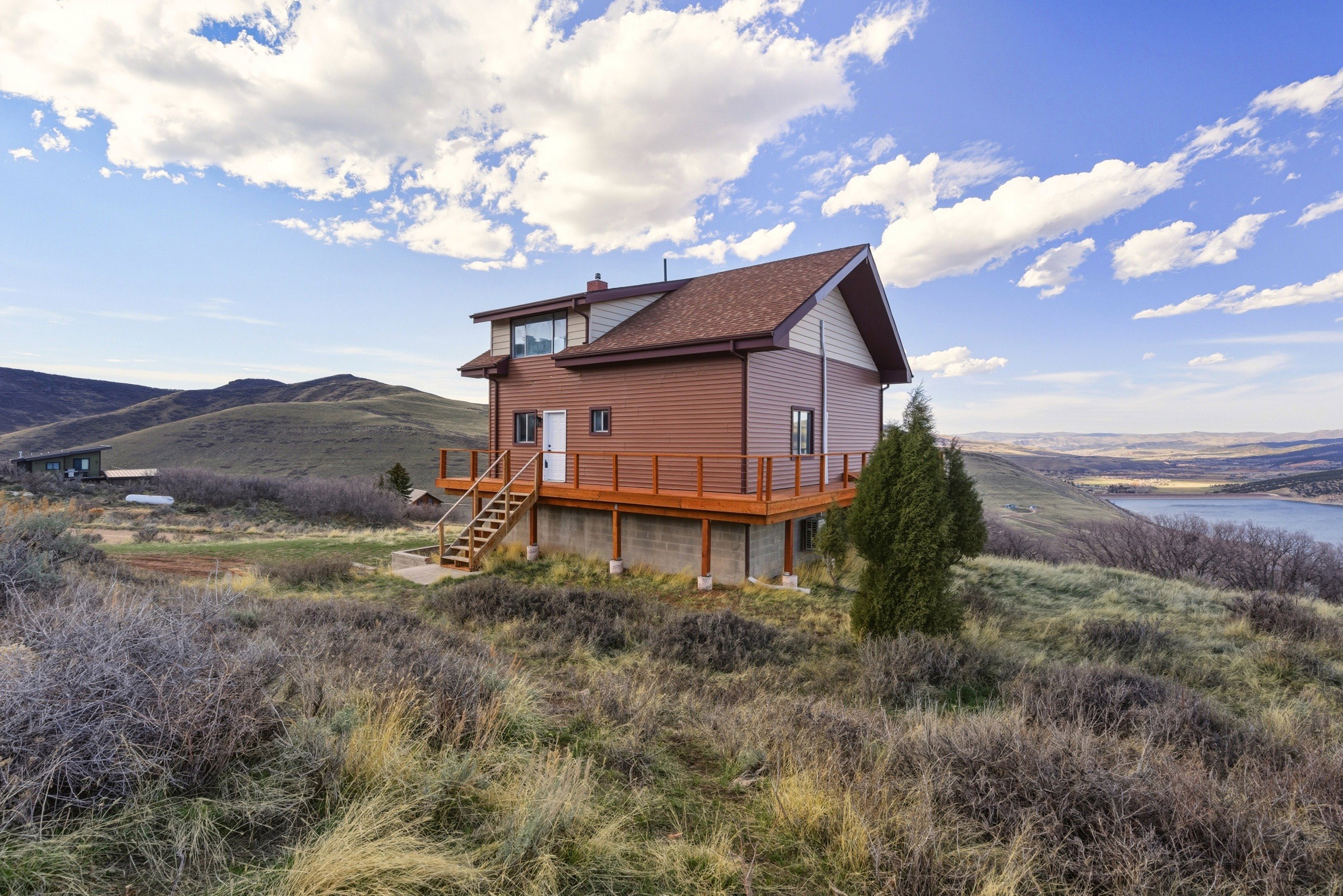 Rear view of property featuring a deck with water view and a chimney