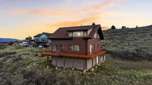 Back of house at dusk featuring a chimney and a deck with mountain view