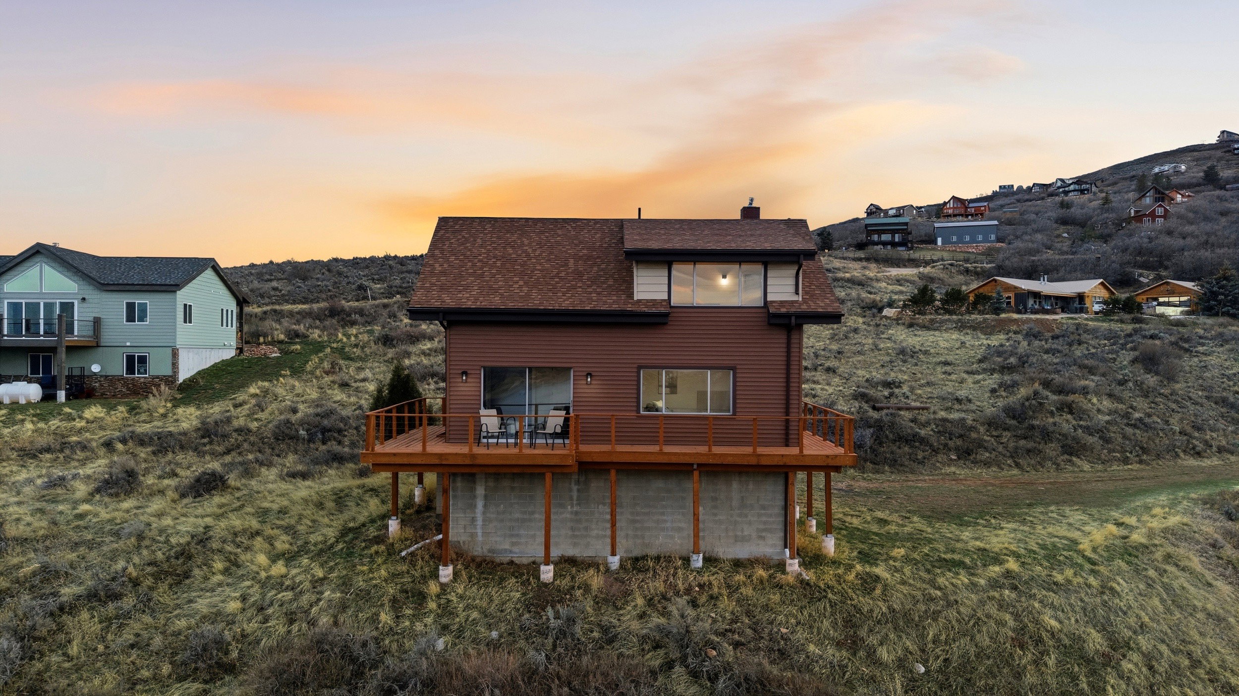 Back of property with a chimney, a wooden deck, and a shingled roof