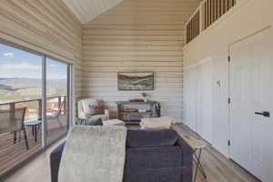 Living room featuring a mountain view, wooden walls, light wood-style floors, and a vaulted wooden ceiling