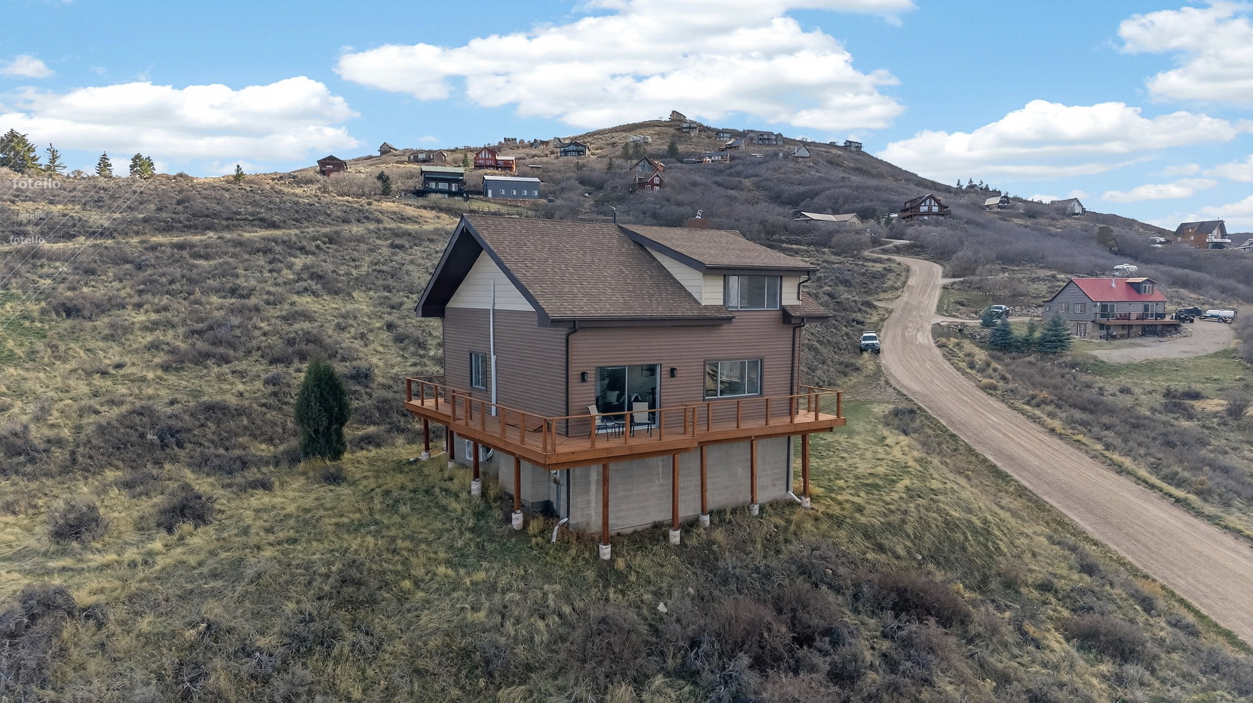 Rear view of property with a deck with mountain view and a garage