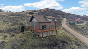 Rear view of property with a deck with mountain view and a garage