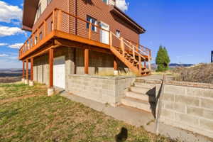 Rear view of property with stairs and an attached garage