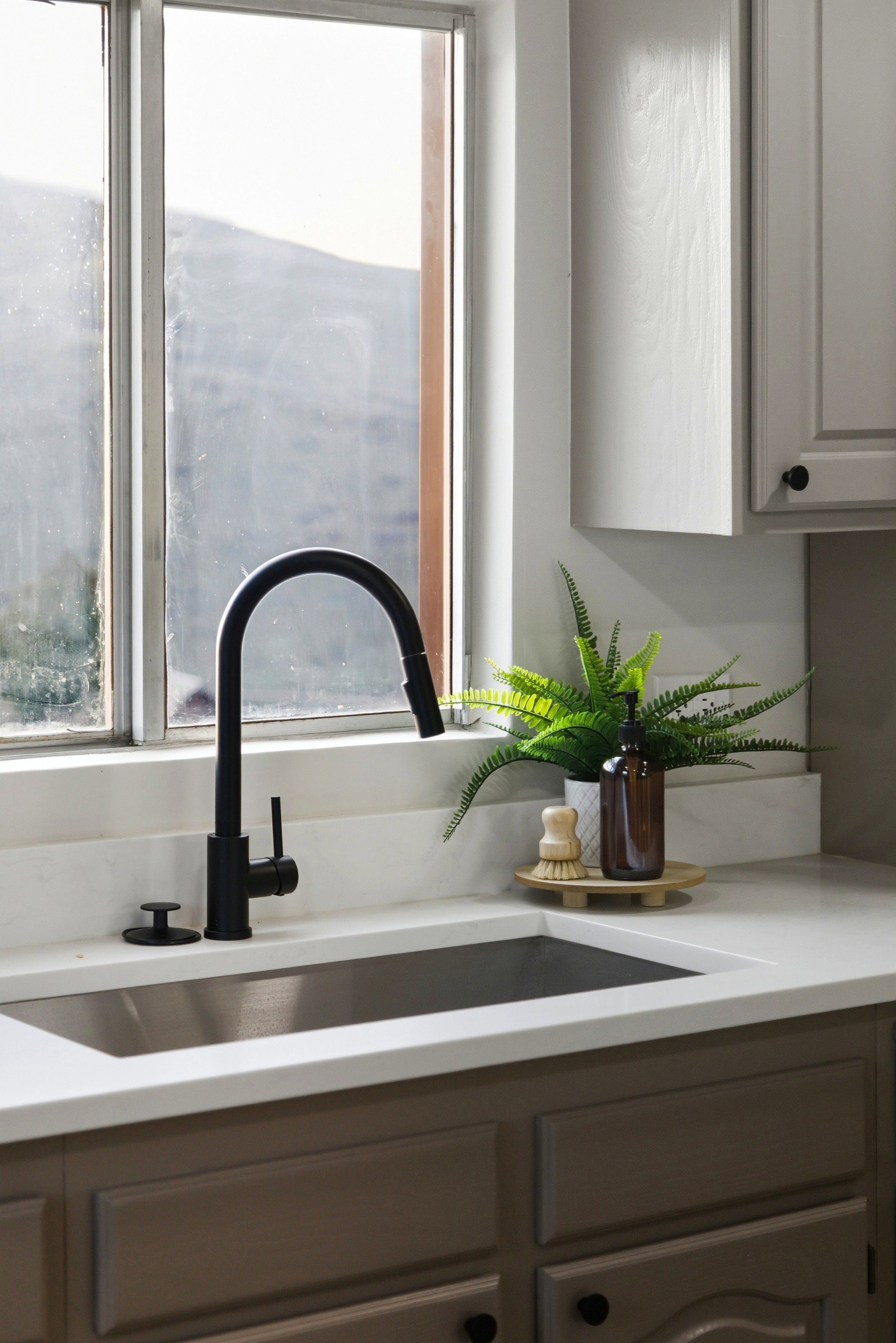 Kitchen view of a sink and gray cabinetry