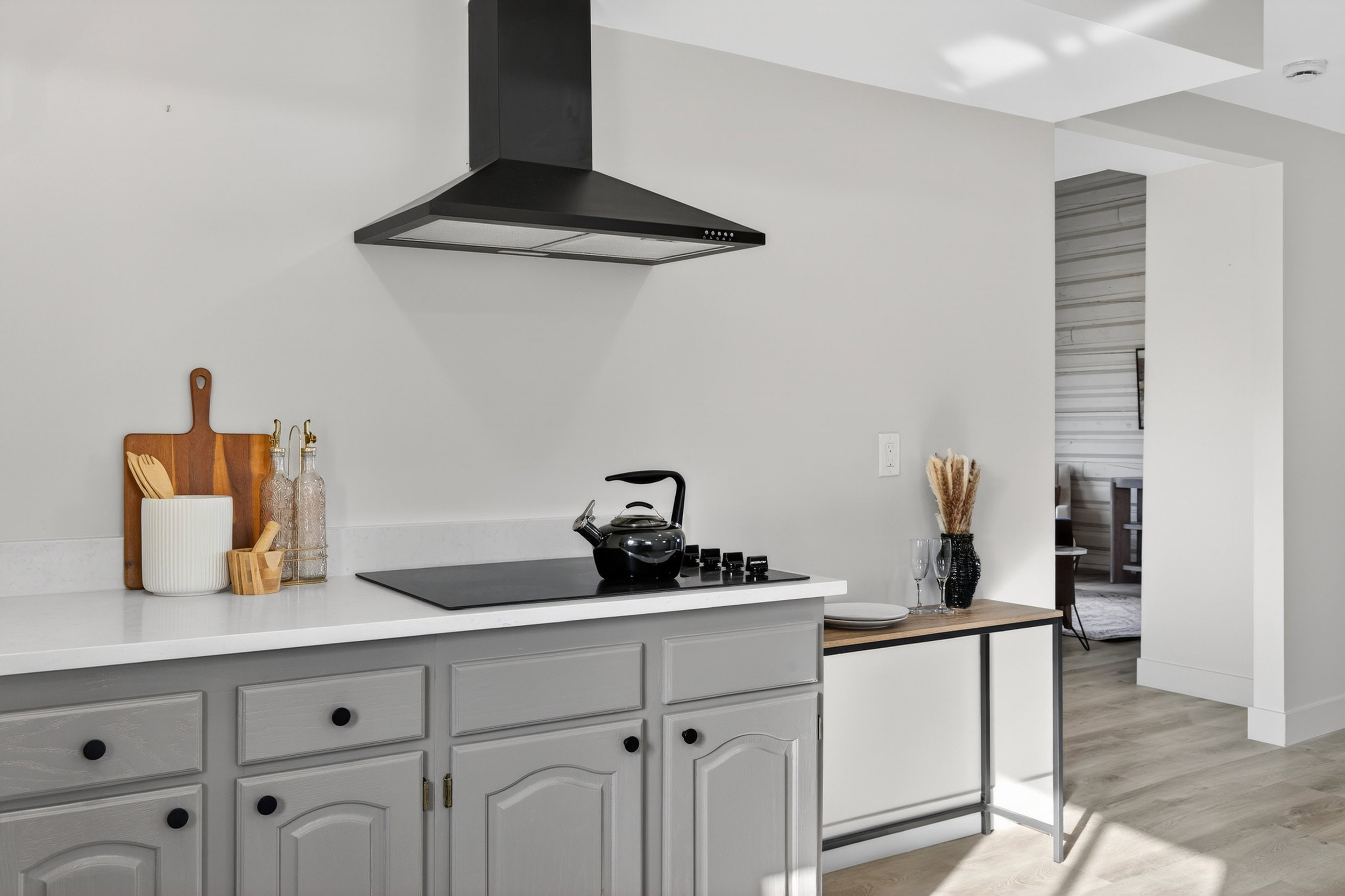 Kitchen with gray cabinetry, light wood-style flooring, and black electric cooktop