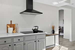 Kitchen with gray cabinetry, light wood-style flooring, and black electric cooktop