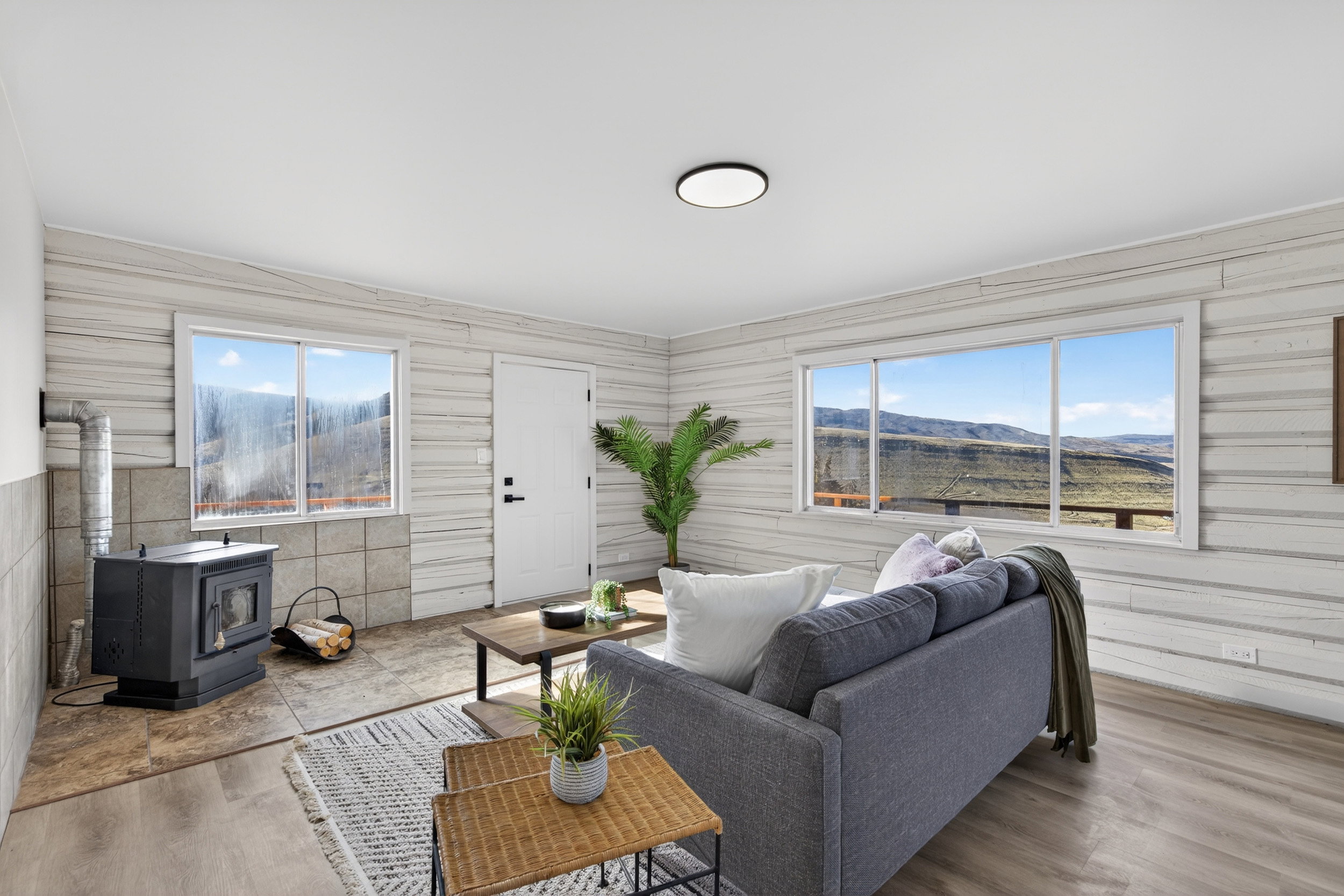 Living room featuring a mountain view, a wood stove, and wood finished floors