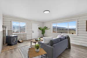Living room featuring a mountain view, a wood stove, and wood finished floors