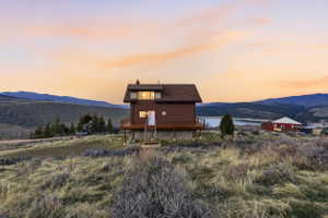 Rear view of house with a chimney and a deck with water view