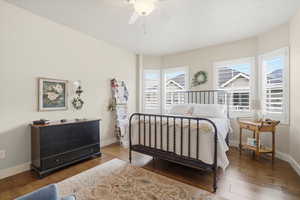 Primary bedroom with dark wood flooring and a ceiling fan