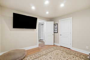 Basement bedroom with lighter wood flooring