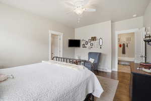 Primary bedroom with dark wood flooring and ceiling fan