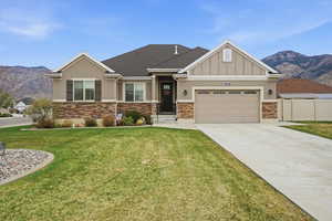 Craftsman house featuring a mountain view, driveway, a garage, stucco and stone siding