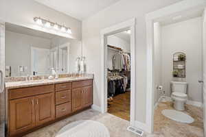 Primary full bathroom featuring light tile patterned floors, double vanity, and a spacious closet