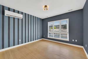 Spacious primary suite featuring a mini split for heating / cooling and light wood-style flooring