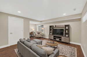 Living room with dark wood finished floors and recessed lighting
