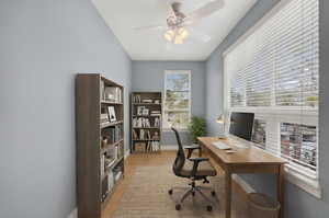 Office space with light wood finished floors and ceiling fan