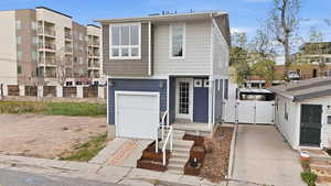 View of front of home with a gate and a garage