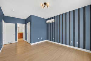 Spacious primary suite featuring light wood-style flooring and a mini split for heating / cooling